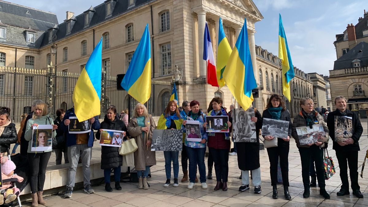 Des Ukrainiens et des associations, photos des victimes à la main, venus au rassemblement de soutien au peuple ukrainien ce 24 février à Dijon